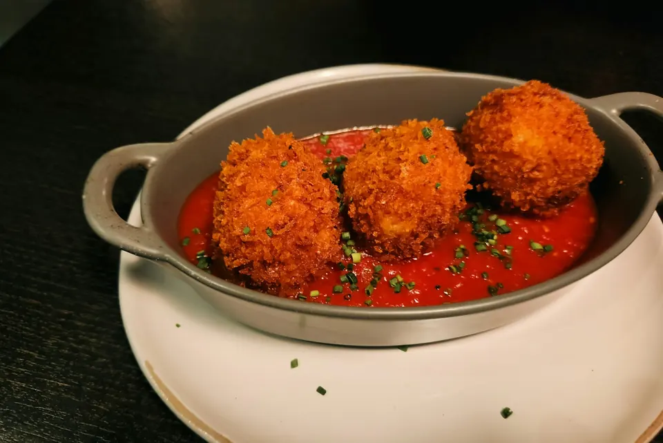 Friterade risbollar serverade med tomatsås