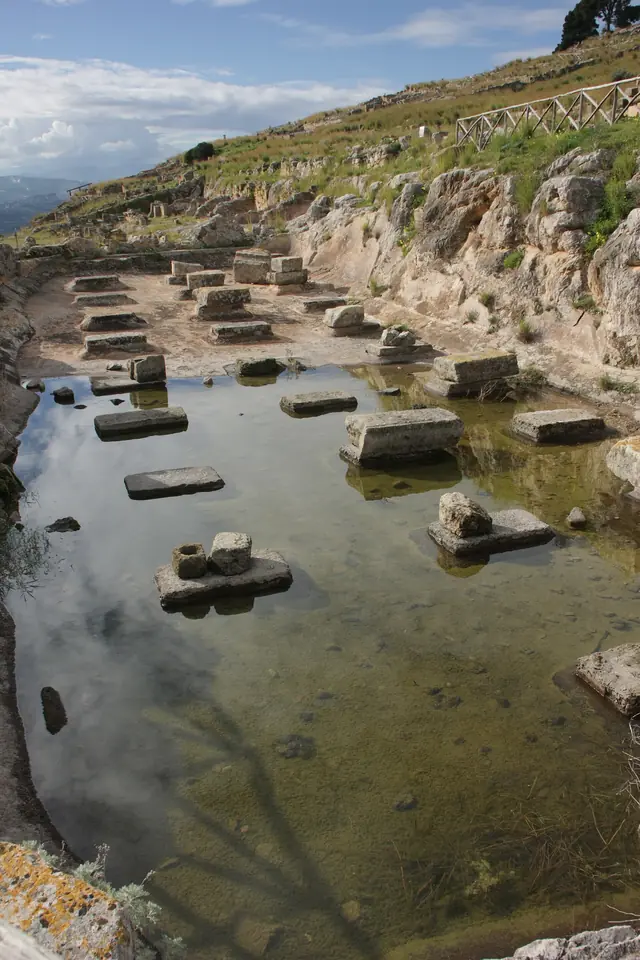 Vattenfylld antik cistern med stenstöd i det arkeologiska området Solunto