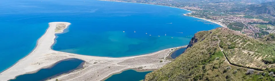 Ljusa sandrevlar och blå laguner vid Marinello sedda uppifrån Tindari