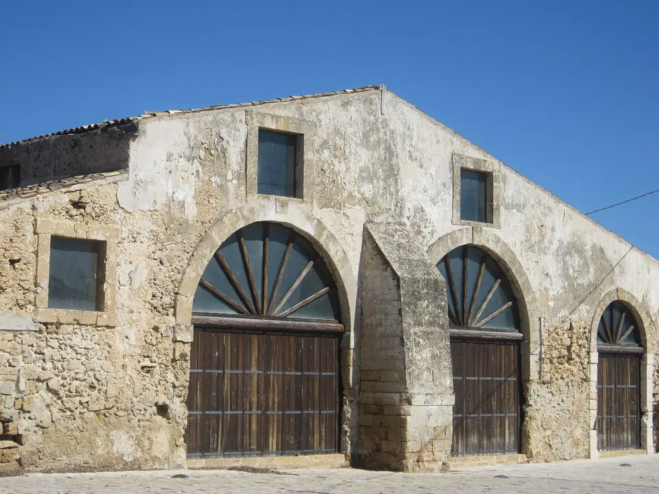 Stenfasad med stora bågformade portar i Marzamemis historiska tonnara