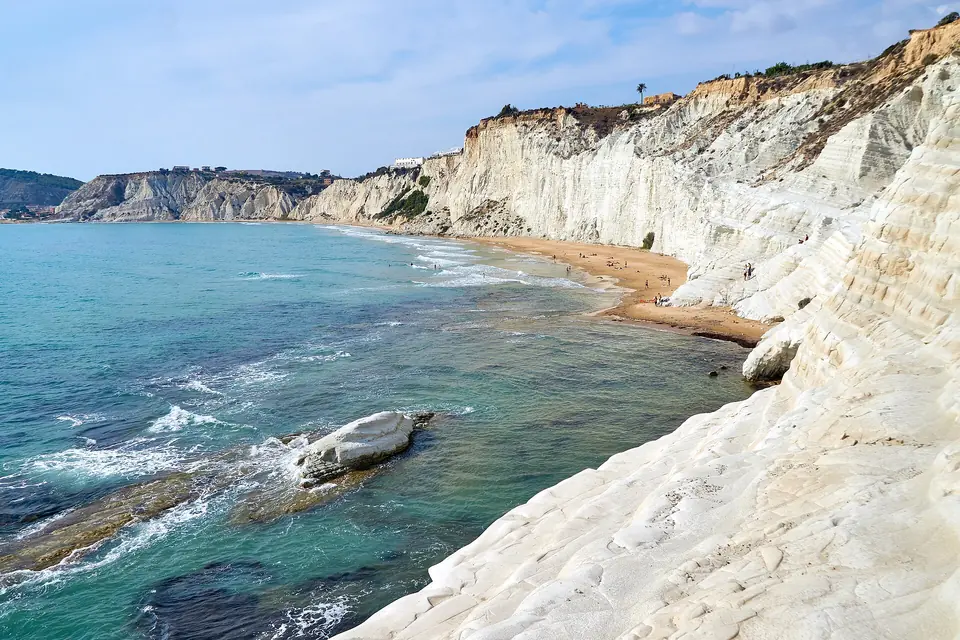 Vita klippor, strand och blågrönt vatten vid Scala dei Turchi