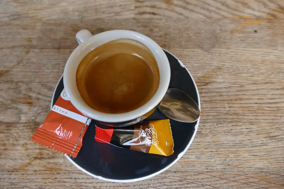 Espresso med socker och en liten sötsak – illustrationsfoto, fotograferingsorten inte verifierad som Sicilien.