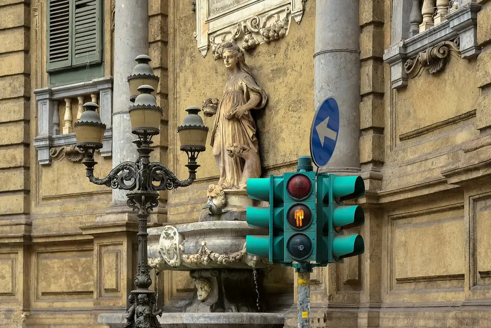 Gatumiljö med fontän och trafikljus i Palermo.