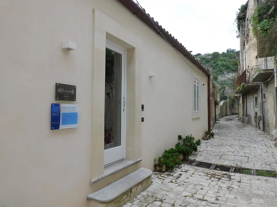 En vit husfasad och gränd på Via Velardo i Ragusa Ibla.