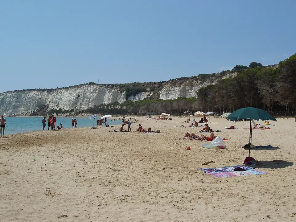 Badstrand framför ljusa klippor på Sicilien.