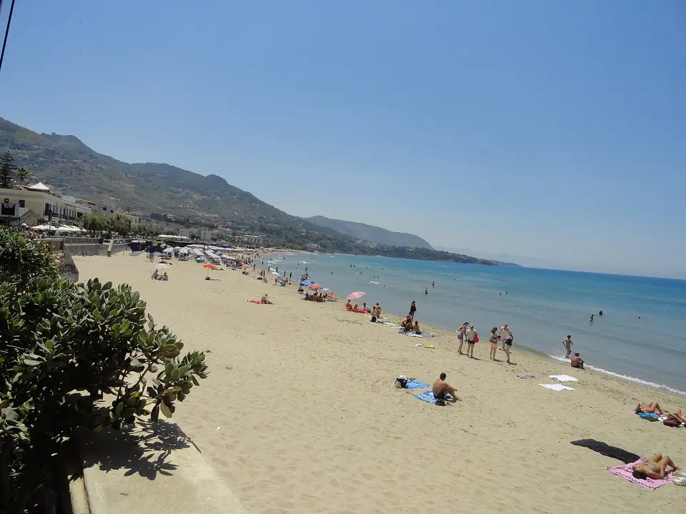 Badgäster och parasoller längs stranden i Cefalù.