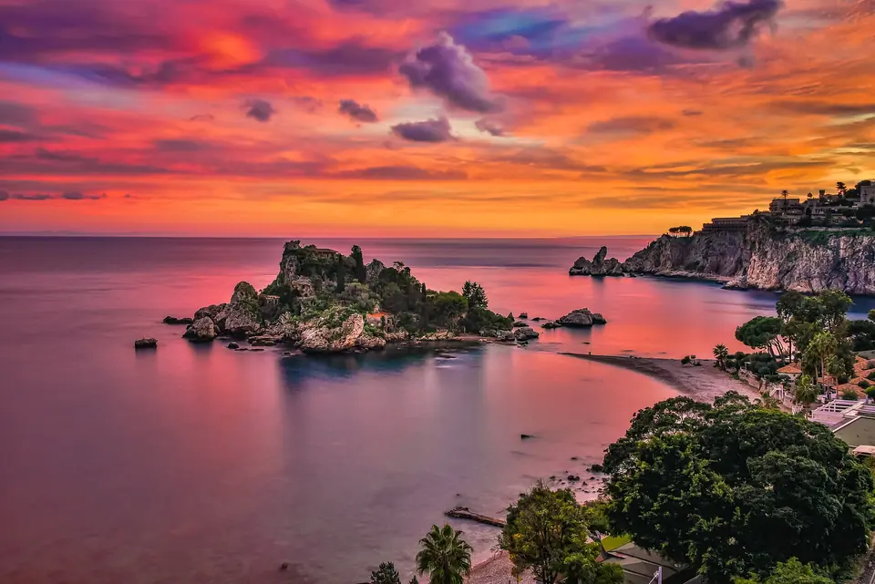 Solnedgångsljus över Isola Bella och Mazzaròbukten vid Taormina.