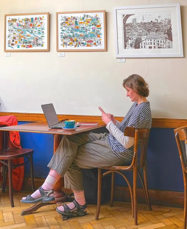 En person med dator och telefon på Secret Café i Bristol i Storbritannien – illustrationsfoto utanför Sicilien.