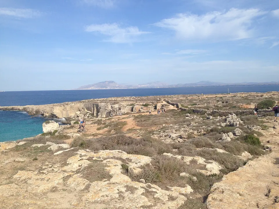 Ljus kalksten och blått hav vid Cala Rossa på Favignana