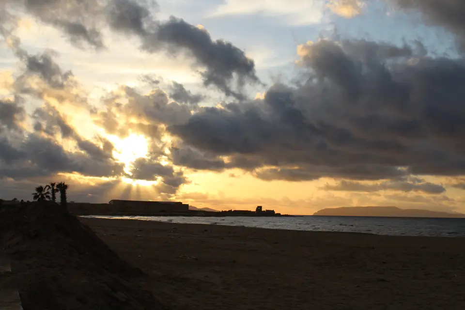 Ljus bakom moln över stranden San Giuliano i Trapani