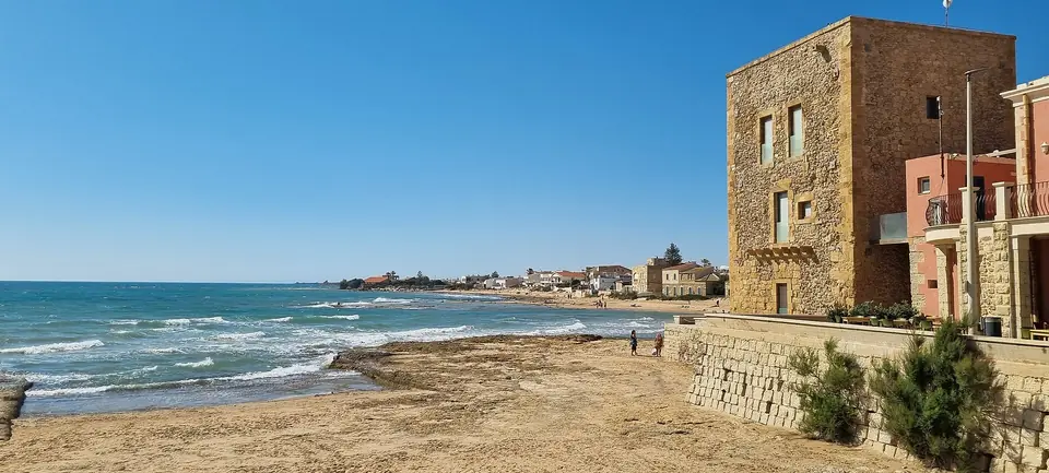 Stentornet Torre Scalambri intill sandstranden i Punta Secca