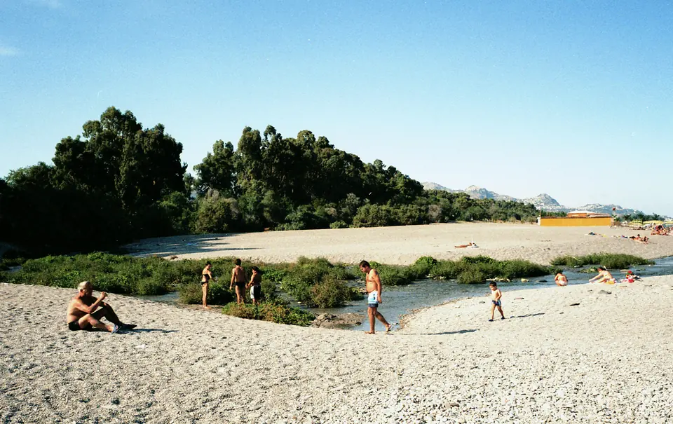 Grusstrand, vattendrag och träd vid Marina di Cottone