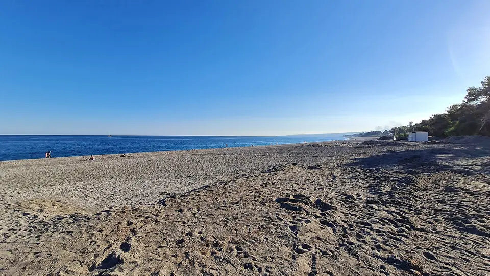 Bred grusstrand och hav vid San Marco i Calatabiano
